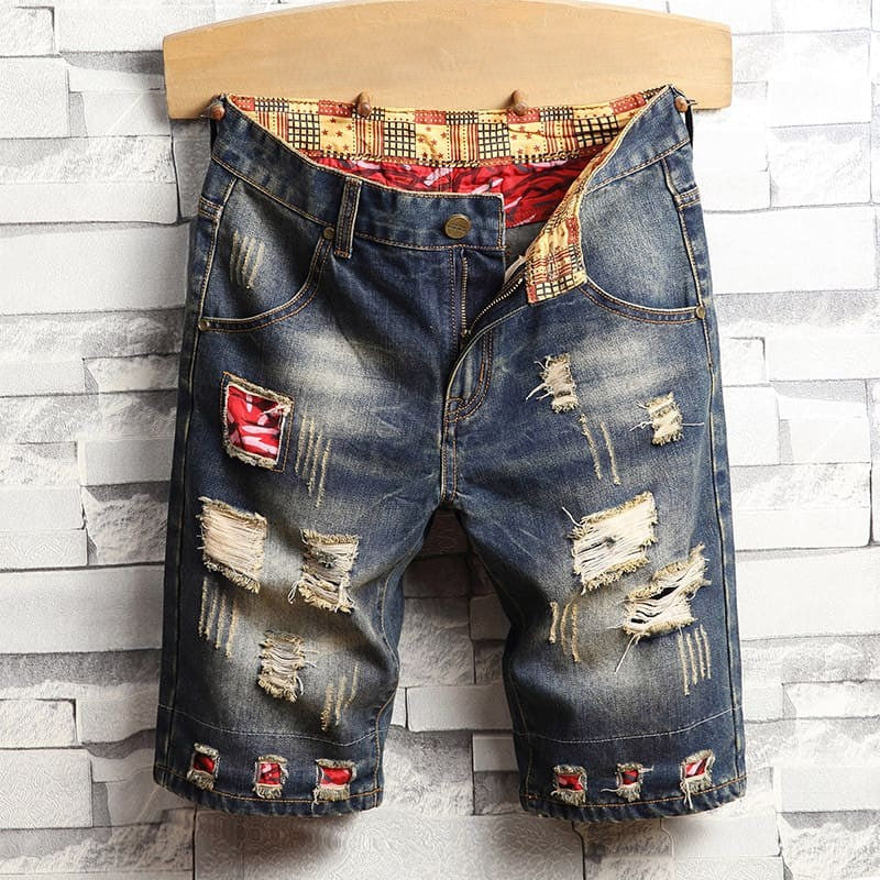 Distressed men's denim shorts with many holes