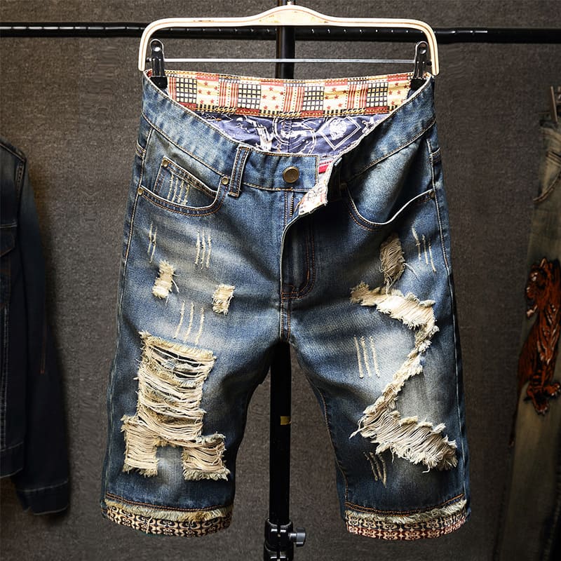 Distressed men's denim shorts with many holes