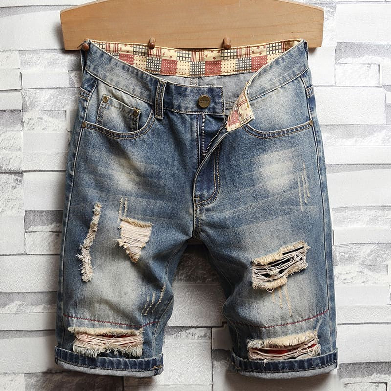 Distressed men's denim shorts with many holes