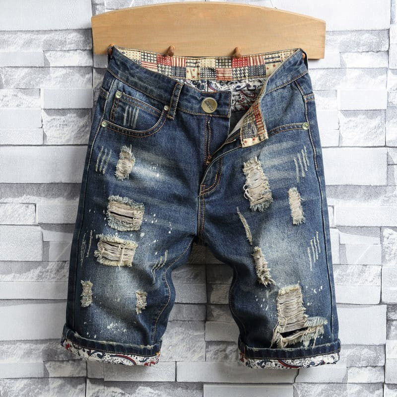 Distressed men's denim shorts with many holes